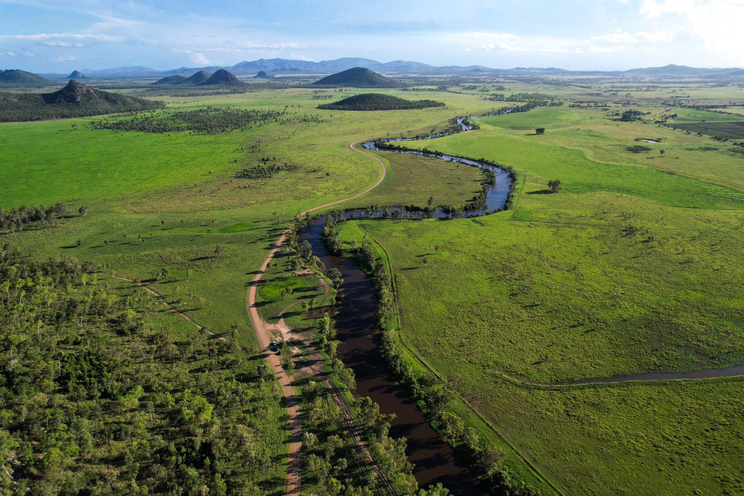 A body of water cuts through green landscapes.